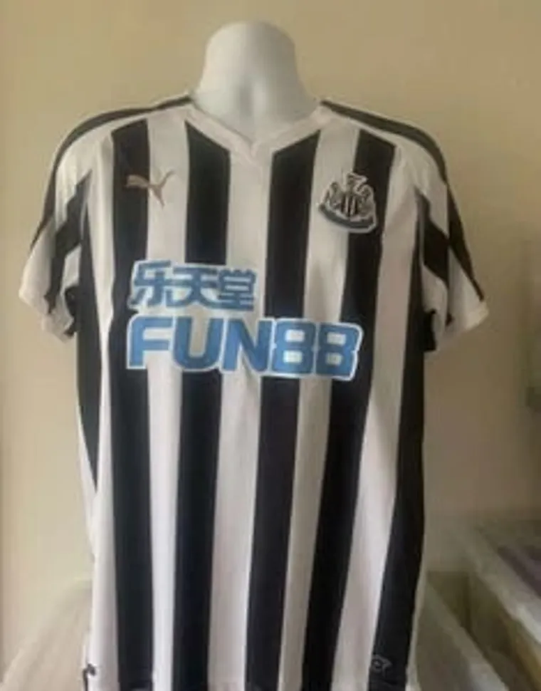 Black and white striped Newcastle United football shirt on a mannequin